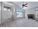 Spacious living room with fireplace, ceiling fan, high ceilings, large windows and wood flooring at 115 W El Freda Rd, Tempe, AZ 85284