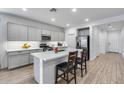 Well-lit kitchen features modern cabinets, stainless appliances, island with seating, and tile flooring at 11574 W Luxton Ln, Avondale, AZ 85323