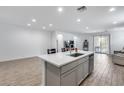 Modern open-plan kitchen featuring an island with a sink and seating at 11574 W Luxton Ln, Avondale, AZ 85323