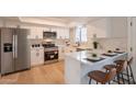 Modern kitchen with white cabinets, stainless steel appliances, and breakfast bar at 1301 N 44Th St, Phoenix, AZ 85008