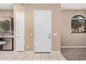 Bright entryway features tile flooring, a white door and view into the kitchen at 1367 S Country Club Dr # 1327, Mesa, AZ 85210
