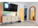 Bright living room showcasing a woven cabinet, decorative mirror, and artistic painted design at 1513 E Sheridan St, Phoenix, AZ 85006