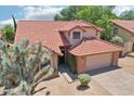 Charming home featuring a red tile roof, a two-car garage, and desert landscaping in the front yard at 1813 E Sheena Dr, Phoenix, AZ 85022