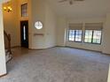 Bright living area with cozy carpet and large window with roller blinds and staircase at 1813 E Sheena Dr, Phoenix, AZ 85022