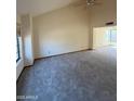 Spacious carpeted living room with high vaulted ceilings, bright windows, and neutral paint at 1813 E Sheena Dr, Phoenix, AZ 85022