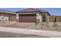 Contemporary home featuring a two-car garage, decorative stone accents, and brick paver driveway at 25109 N 174Th Ln, Surprise, AZ 85387