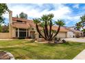 Charming two-story home features a red tile roof, two-car garage and mature palm trees at 3337 E Glade Cir, Mesa, AZ 85204
