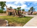 Charming two-story home features a red tile roof, two-car garage and mature palm trees at 3337 E Glade Cir, Mesa, AZ 85204