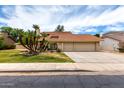 Charming two-story home features a red tile roof, three-car garage and mature palm trees at 3337 E Glade Cir, Mesa, AZ 85204