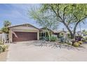 Single story home with a brick exterior, well-kept lawn, mature trees, and desert landscaping at 402 E Claremont St, Phoenix, AZ 85012