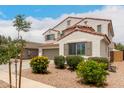 A delightful two-story house with a red tile roof and lush greenery, showcasing the home's curb appeal at 4142 E Sandy Way, Gilbert, AZ 85297