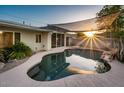 Backyard pool with rock features and overhead shade sail creates an inviting outdoor oasis at 8408 E Rancho Vista Dr, Scottsdale, AZ 85251