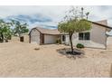 Charming single-story home with low-maintenance desert landscaping and mature shade tree at 11021 N 55Th Dr, Glendale, AZ 85304