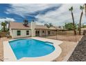 Backyard pool is surrounded by concrete and rocks in a yard enclosed by a wrought iron fence at 11021 N 55Th Dr, Glendale, AZ 85304