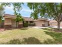 Charming single-story home featuring a well-manicured lawn, desert landscaping, and a two-car garage at 1114 N Leland Ct, Gilbert, AZ 85233