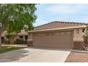 Charming single-story home featuring a well-manicured lawn, desert landscaping, and a two-car garage at 1114 N Leland Ct, Gilbert, AZ 85233