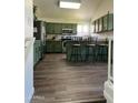 Open kitchen boasts wood flooring, stainless steel appliances and a breakfast bar, creating a functional and stylish space at 113 N Albert Dr, Chandler, AZ 85226