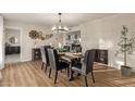 Elegant dining room features a stylish chandelier, modern decor, and an adjacent fireplace at 12866 W Orange Dr, Litchfield Park, AZ 85340