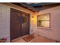 Welcoming front entrance featuring a modern door, stylish wreath, and decorative lantern on a brick facade at 12866 W Orange Dr, Litchfield Park, AZ 85340
