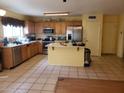 Spacious kitchen with stainless steel appliances, wood cabinets, tile floors and a kitchen island at 1623 E Fremont Rd, Phoenix, AZ 85042