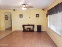 Open-concept living room featuring wood-laminate floors, ceiling fan, and bright neutral paint at 1623 E Fremont Rd, Phoenix, AZ 85042