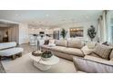 Inviting living room with plush sofa, stylish decor, and an open layout connecting to the modern kitchen and dining area at 16714 W Audrey Ln, Surprise, AZ 85387