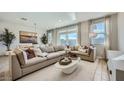 Comfortable living room featuring a large sectional sofa, elegant decor, and natural light from the large windows at 16714 W Audrey Ln, Surprise, AZ 85387