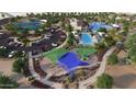 Community aerial view featuring a splash pad, playground, pool, tennis courts, parking lot, and clubhouse at 16739 W Charlotte Dr, Surprise, AZ 85387