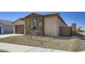 Angle view of a single-story home showing desert landscaping, neutral color palette and a quaint design at 16933 W Bronco Trl, Surprise, AZ 85387