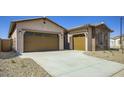 A single-story home showcasing its dual-car garage, a clean driveway, and low-maintenance desert landscape at 16933 W Bronco Trl, Surprise, AZ 85387