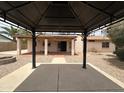 Backyard view showcasing a covered patio and desert landscaping at 2209 W Los Arboles Pl, Chandler, AZ 85224