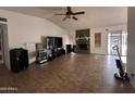 Open living room featuring tile floors, a vaulted ceiling and a stone fireplace at 2209 W Los Arboles Pl, Chandler, AZ 85224