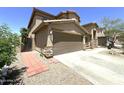 Side view of home shows the two-car garage, brick pathway, and desert landscaping at 33506 N 24Th Dr, Phoenix, AZ 85085