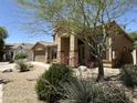 Home showcasing an arched entryway, desert landscaping, and mature shade tree at 33506 N 24Th Dr, Phoenix, AZ 85085