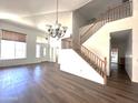 Open living area with wood-look flooring, soaring ceilings, and a staircase to the second floor at 33506 N 24Th Dr, Phoenix, AZ 85085