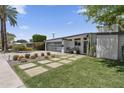 A modern home boasts desert landscaping, concrete pavers, and a stylish glass garage door at 3402 E Sells Dr, Phoenix, AZ 85018