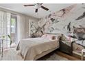 Comfortable bedroom with hardwood flooring, accent wall, and sliding glass door to balcony at 3633 N 3Rd Ave # 1035, Phoenix, AZ 85013