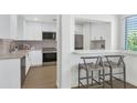 Modern kitchen with stainless steel appliances and white cabinets with bar stool seating at 4201 E Camelback Rd # 70, Phoenix, AZ 85018