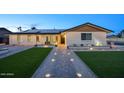 Beautiful house featuring an illuminated walkway, new landscaping, and well-kept front lawn at 4202 W Purdue Ave, Phoenix, AZ 85051