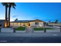 Inviting home exterior showcasing manicured landscaping, solar panels, and welcoming entrance lights at 4202 W Purdue Ave, Phoenix, AZ 85051