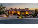 Charming home featuring stone accents, professional landscaping and a paver driveway at twilight at 4328 N Pinnacle Ridge Cir, Mesa, AZ 85207