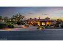 Beautiful home featuring professional landscaping, stone accents, and a paver driveway at twilight at 4328 N Pinnacle Ridge Cir, Mesa, AZ 85207
