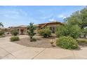 Inviting home exterior with desert landscaping, mature trees, and a well-manicured front yard at 4404 W Ellis St, Laveen, AZ 85339