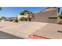 View of home featuring a two-car garage and charming landscaping at 619 E Jensen St # 34, Mesa, AZ 85203