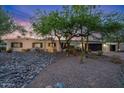 Single story home with desert landscaping, mature trees, and three car garage at 6310 E Desert Cove Ave, Scottsdale, AZ 85254