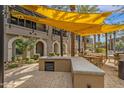 Outdoor community space with grilling station, tables, and shade structures for resident enjoyment at 6565 E Thomas Rd # 1096, Scottsdale, AZ 85251