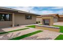 Cozy outdoor fireplace and patio area surrounded by lush lawn and charming stone pavers at 8214 E Northland Dr, Scottsdale, AZ 85251