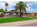 Charming single-story home with lush green lawn and mature trees, with great curb appeal at 8214 E Northland Dr, Scottsdale, AZ 85251