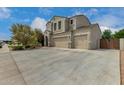 Spacious home featuring a three-car garage, a long driveway, and mature landscaping at 887 W Santa Gertrudis Trl, San Tan Valley, AZ 85143