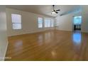 Spacious living room with hardwood floors, ceiling fan, and large windows allowing for plenty of natural light at 1020 W Sunward Dr, Gilbert, AZ 85233